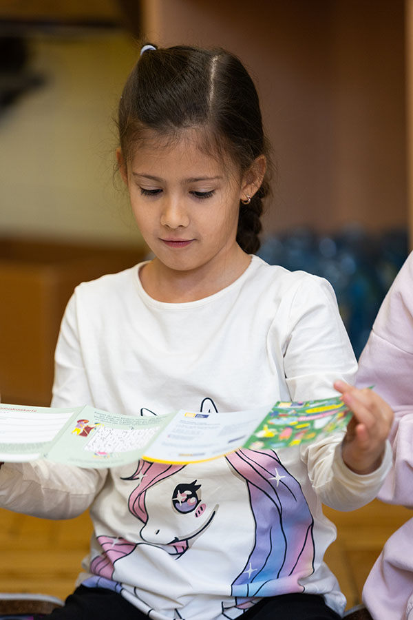 Ein Kind schaut einen Lesepass an. 