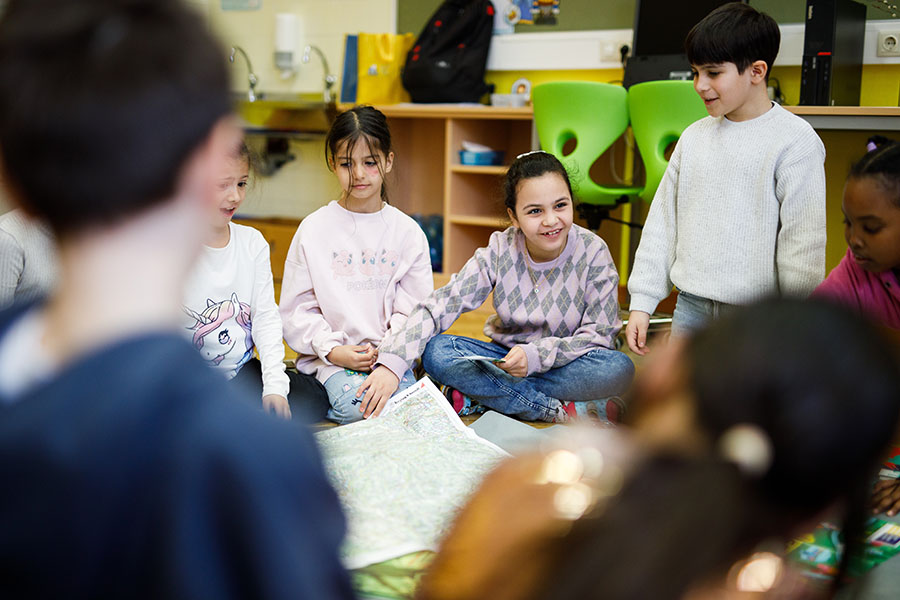 Kinder lesen eine Landkarte.